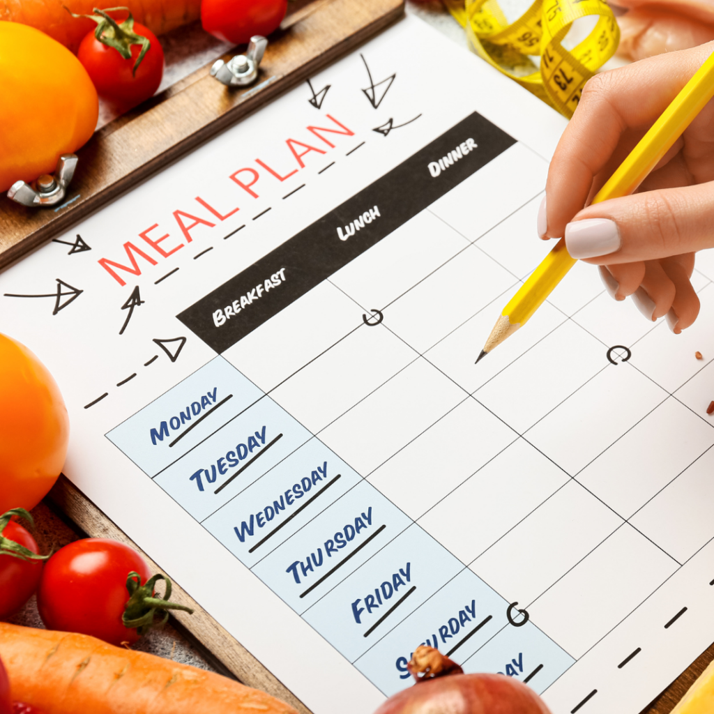 A image of a person's holding a pencil writing a weekly meal plan